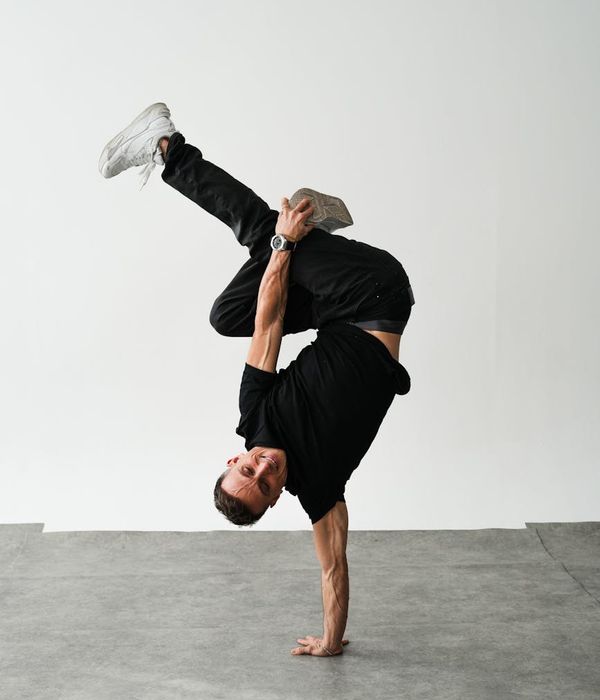 Athletic man performing a dynamic strength exercise in a minimalist studio.