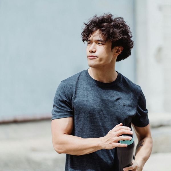 Man stretching after a workout, looking relaxed and energized outdoors.